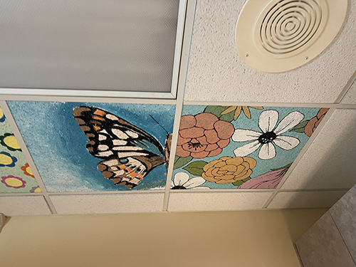 Beautiful ceiling tiles painted with butterflies and flowers by students